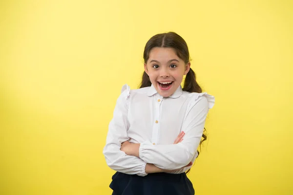 Amazing news. Girl school uniform smiling cheerful face wondering yellow background. Child excited back to school end continue education. Schoolgirl formal outfit look cute. Girl happy back to school — Stock Photo, Image