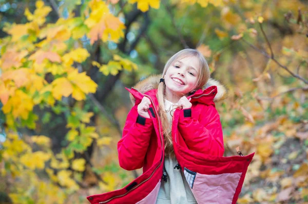 Siéntete tan cómodo con una chaqueta cálida. Chica feliz en abrigo disfrutar de otoño parque natural. Los niños usan abrigo de moda con capucha. Ropa de otoño y concepto de moda. Niño rubio pelo largo caminando en chaqueta caliente al aire libre — Foto de Stock