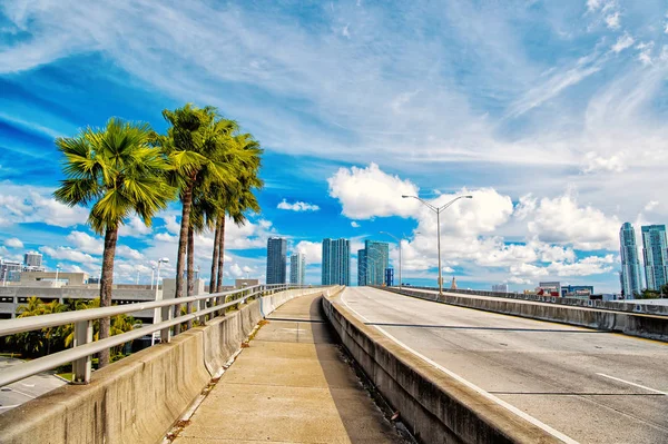 Αυτοκινητόδρομος με ουρανοξύστες στο μπλε συννεφιασμένο ουρανό — Φωτογραφία Αρχείου