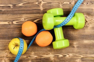 metre bant dumbell ağırlık, elma, portakal, diyet kavramı ile