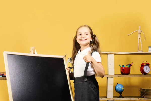 Material escolar e infantil, fundo amarelo. Estudante com rosto alegre — Fotografia de Stock