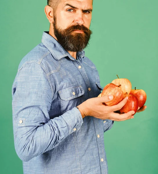 Guy presents homegrown harvest. Farmer with strict face
