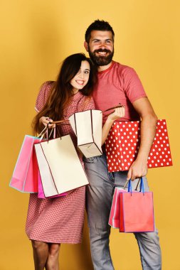 Sakallı bir adam ve gülen yüzlü bir kız alışveriş yapıyor.