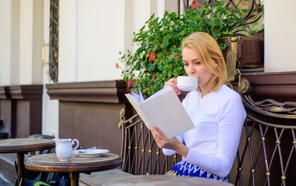 Муг хорошої кави і приємної книги найкраще поєднання для ідеальних вихідних. Дівчина п'є каву щоранку в одному місці щоденного ритуалу. Книжковий хробак концепція дозвілля. Жінка п'є терасу кафе на відкритому повітрі — стокове фото
