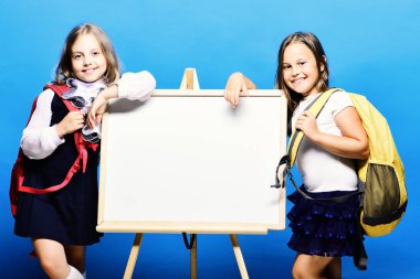 Mavi arka plan tahtada işaret yanındaki kız öğrenciler