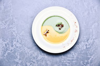 Gri dokuda ıspanak ve balkabağı kremalı çorba.