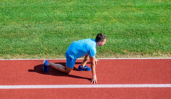 Corredor atleta prepararse para la carrera. Consejos para principiantes. Hombre atleta de pie baja posición de inicio camino del estadio. Corredor listo para salir. Ejercicios de movilidad conjunta para mejorar la flexibilidad y la función — Foto de Stock