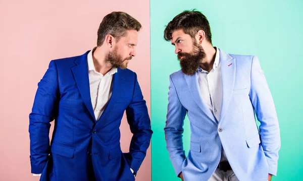 Tense face expression competitors. Business competition and confrontation. Business partners competitors in suits with tense bearded faces. Businessmen stylish appearance jacket pink blue background — Stock Photo, Image