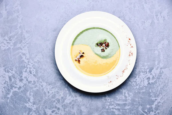 Soupe aux épinards et crème de citrouille sur fond de texture grise — Photo