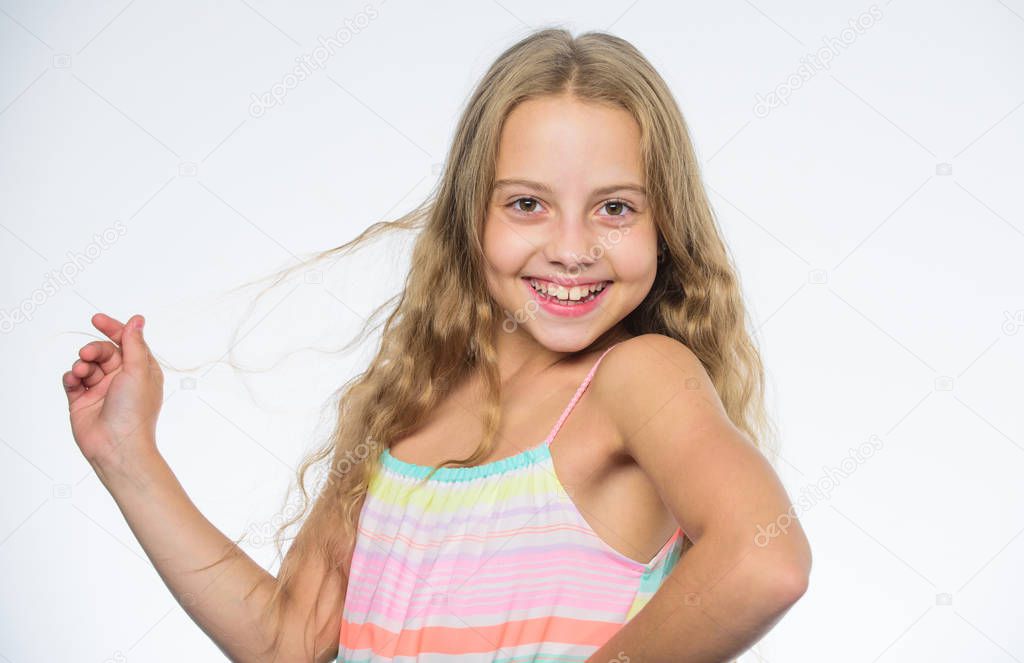 Teaching your child healthy hair care habits. Hair care tips for kids. Kid little girl happy look at camera. How to care for childs hair. Girl long hair smiling face white background. Natural beauty