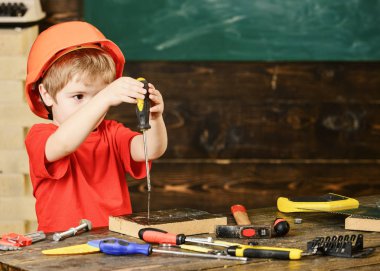 İki eliyle bir tornavida tutan küçük bir çocuk. Küçük çocuk yeni bir oyuncak keşfetti. Erken öğrenme kavramı