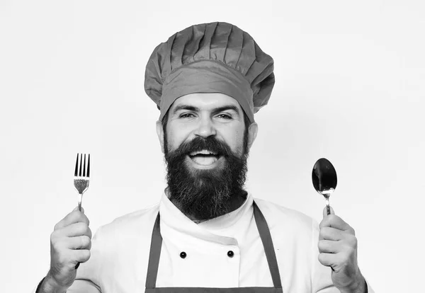 Homme avec barbe tient fourchette et cuillère sur fond blanc — Photo
