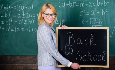 Okul öğretmeni mutlu hoş geldiniz öğrenciler. Öğretim yılı büyük başlangıcı. En iyi yolu öğrenciler okula geri hoş geldiniz. Öğretmen kadın tutun blackboard yazıt geri okula. Tekrar okul zamanı