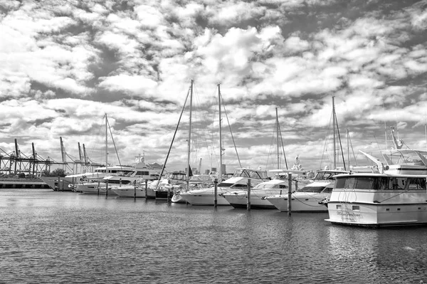 Båtar och segel båtar i hamn på molnig himmel. Segling och segling. Lyxiga resor på båt. Sommarsemester på havet. Vattentransport och fartyg — Stockfoto