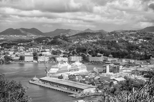 Castries, st.lucia - 26 de noviembre de 2015: Ocean liner in sea port on mountain landscape. Ciudad en la orilla azul del mar con cielo nublado. Viajes de lujo en barco, transporte acuático. Vacaciones de verano en isla — Foto de Stock