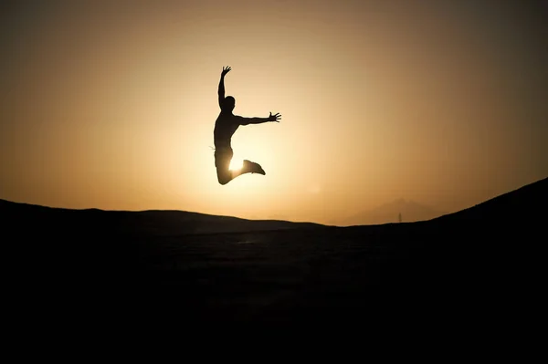 Adam siluet, günbatımı gökyüzü atlama — Stok fotoğraf