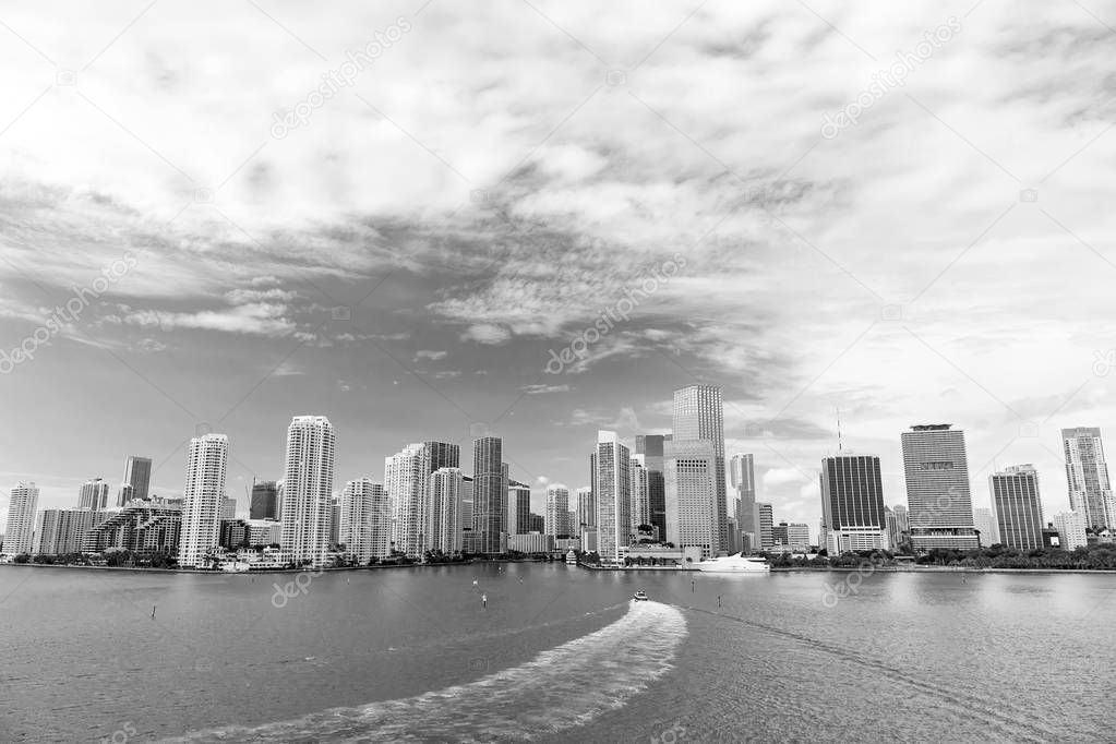 Aerial view of Miami skyscrapers with blue cloudy sky, boat sail