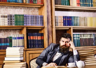 Akıllı takım elbiseli olgun adam edebiyat hakkında düşünüyor.