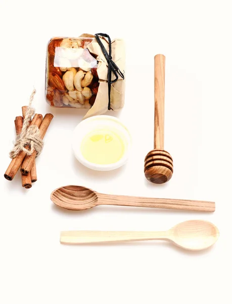 Conjunto de jarro com nozes, mel, talheres de madeira e canela. — Fotografia de Stock