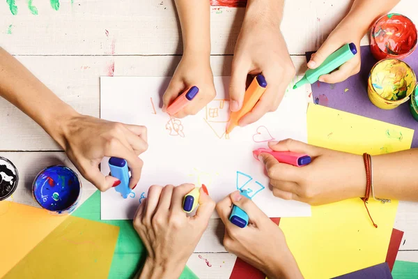 Mãos segurar marcadores coloridos e desenhar, vista superior — Fotografia de Stock