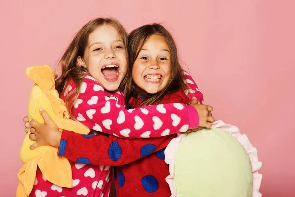 Dziewczyny w kolorowych polka notacji piżamy posiadają zabawne poduszki jasne — Zdjęcie stockowe