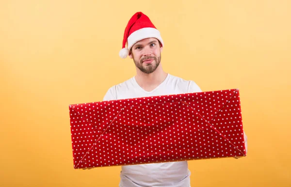 Mannen i santa hatt hålla julklapp. På morgonen innan Xmas. leverans julklappar. man njuta av semestern. Christmas sammansättning. God jul och god jul. Färgglada roligt — Stockfoto