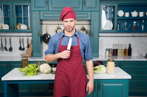 Man chef wear apron cooking in kitchen. Man use sharp ceramic knife. Sharp knife professional tool. Chef choose professional tools. Kitchen utensils and tools. Chef hold knife tool ready to cook — Stock Photo, Image