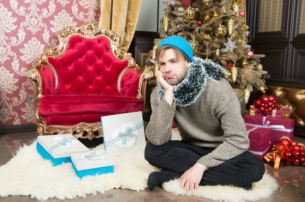 El tipo con cara infeliz se sienta en el árbol de Navidad — Foto de Stock