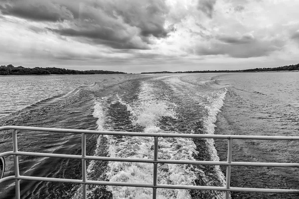 Manaus, Brezilya mavi denizde su üzerinde iz. Bulutlu gökyüzü ufukta deniz kıyısında. Yolculuk tutkusu keşif ve macera. Hız ve enerji kavramı. Su ile seyahat