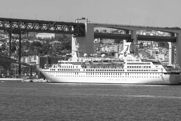 Lisboa, Portugal - 03 de abril de 2010: transatlântico no porto marítimo. Navio em água sob ponte no dia ensolarado. Recipiente de água no mar azul. Viajando pela água. Wanderlust em férias de verão — Fotografia de Stock