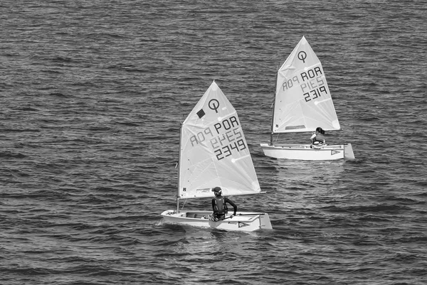 Lisbon, Portugal - April 03, 2010: yachts in blue sea. Children athletes participate in race on sunny day. Sea sailing championship. Regatta and yacht sailing sport. Travelling by water with adventure — Stock Photo, Image