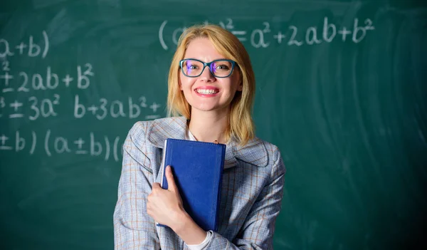 Gran carta de recomendación. Mujer sonriente profesora sostener libro pie pizarra frontal. Recomendación para el concepto universitario. Solicitar carta de recomendación profesor. Recomendación consejos de aplicación —  Fotos de Stock