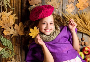 Örme şapka trend sonbahar sezonu. Kız yatıyordu ahşap arka plan yaprakları yukarıdan düşmüş. Aksesuar moda ayrıntı ördü. Çocuk kız parlak yumuşak örme şapka bere. Sonbahar moda örgü aksesuar