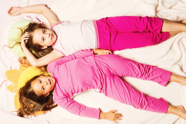 Dzieci w różowych pidżamach bawić. Dzieci z zmęczone twarze — Zdjęcie stockowe