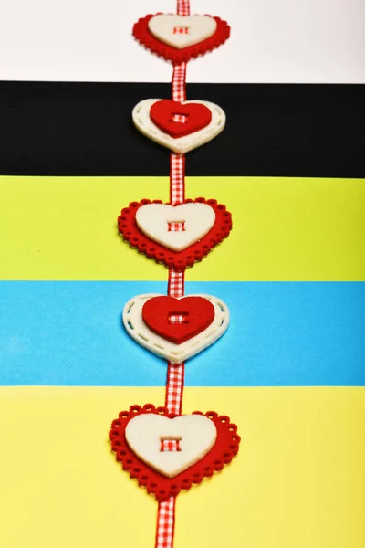 Handmade heart decoration on colourful striped background