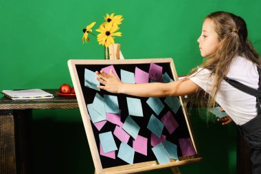 Çocuk ve okul malzemeleri yeşil duvar arka planında