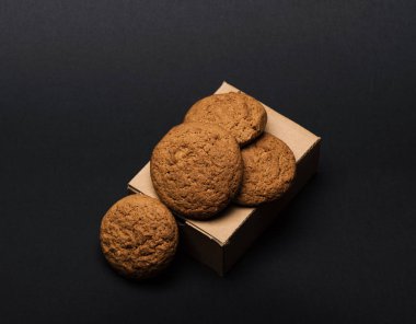 Koyu gri arkaplanda karton kutuda kurabiyeler.