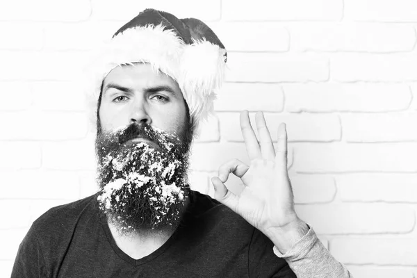 Όμορφος γενειοφόρος άνδρας με κομψό μουστάκι και καιρό χιονισμένο γένια στο σοβαρό πρόσωπό δείχνει δροσερό σε φόντο λευκό τούβλο τοίχο. — Φωτογραφία Αρχείου