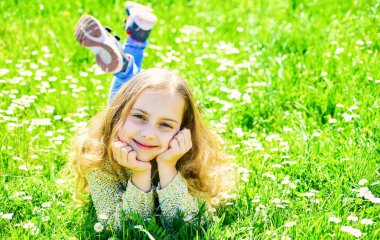 Yüz gülümseyerek kıza harcamak açık havada eğlence. Altın Çağ kavramı. Çocuk çayır yalancı bahar güneşli hava keyfini çıkarın. Kız grassplot, yeşil renkli, kopya alanı çim üzerinde yalan