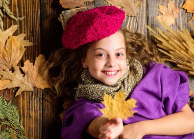 Aksesuar moda ayrıntı ördü. Çocuk kız parlak yumuşak örme şapka bere. Sonbahar moda örgü aksesuar. Örme şapka trend sonbahar sezonu. Kız yatıyordu ahşap arka plan yaprakları yukarıdan düşmüş