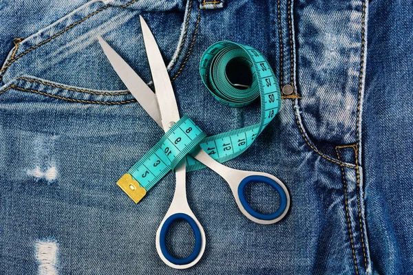 Tailors tools on jeans pocket: making clothes and design concept