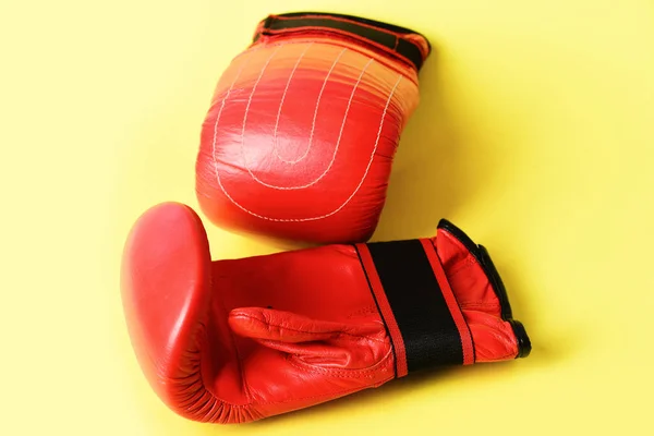 Manoplas para boxeo en color rojo aisladas sobre fondo amarillo —  Fotos de Stock