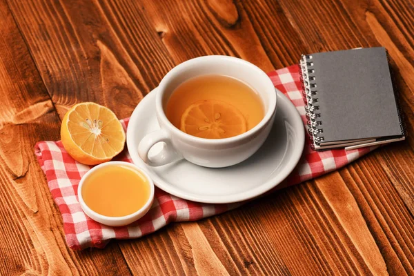 Čajový šálek s medem a malý notebook s útulným složením — Stock fotografie