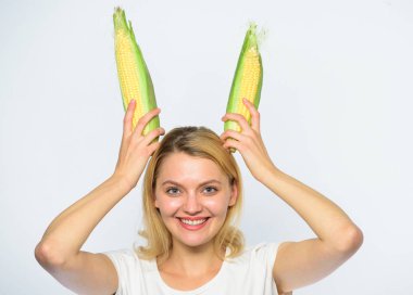 Vejetaryen beslenme kavramı. Kadın sarı Mısır Mısır koçanı beyaz arka plan üzerinde tutun. Kız neşeli oynak ruh tavşan kulakları olgun Mısır tutun. Gıda vejetaryen ve sağlıklı organik ürün. Hasat ve eğlenceli