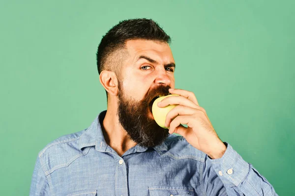 Ο τύπος παρουσιάζει ντόπια συγκομιδή. Ο αγρότης με πεινασμένο πρόσωπο τρώει μήλο — Φωτογραφία Αρχείου