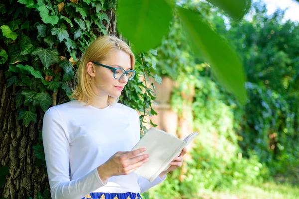 Donna bionda prendersi una pausa rilassante nel parco libro di lettura. Ragazza rilassante con libro sfondo verde natura. Letteratura come hobby. Le ragazze appassionate di libri continuano a leggere. Bestseller concetto di top list — Foto Stock