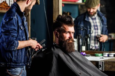 Acımasız sakallı istemci kesme makinesi styling saç ile berber. Hipster istemci Başlarken saç kesimi. Hipster yaşam tarzı kavramı. Kuaför saç kesme makinesi ile saç modeli sakallı adam berber arka plan için çalışır