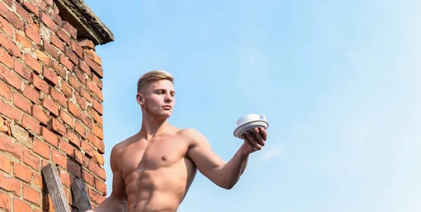 男筋肉の胸、裸の胴体は、コーヒーの空の背景のカップを保持します。男の筋肉の運動選手のボディービルダーは、コーヒーを提供しています。強い筋肉は、男らしさのセクシュアリティを強調します。セクシーな胴体魅力的なウェイター — ストック写真