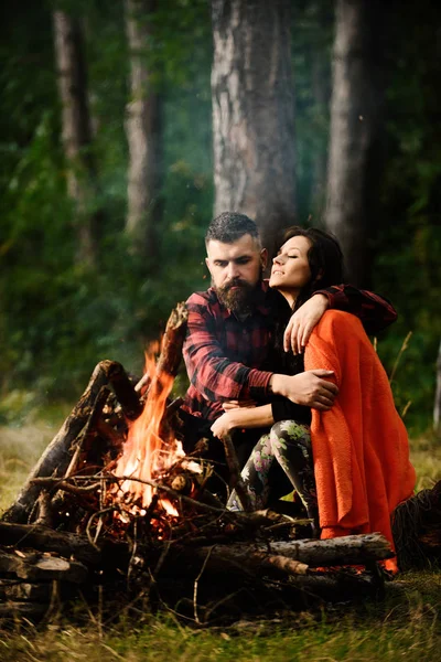 Man with woman hugs and warm near bonfire