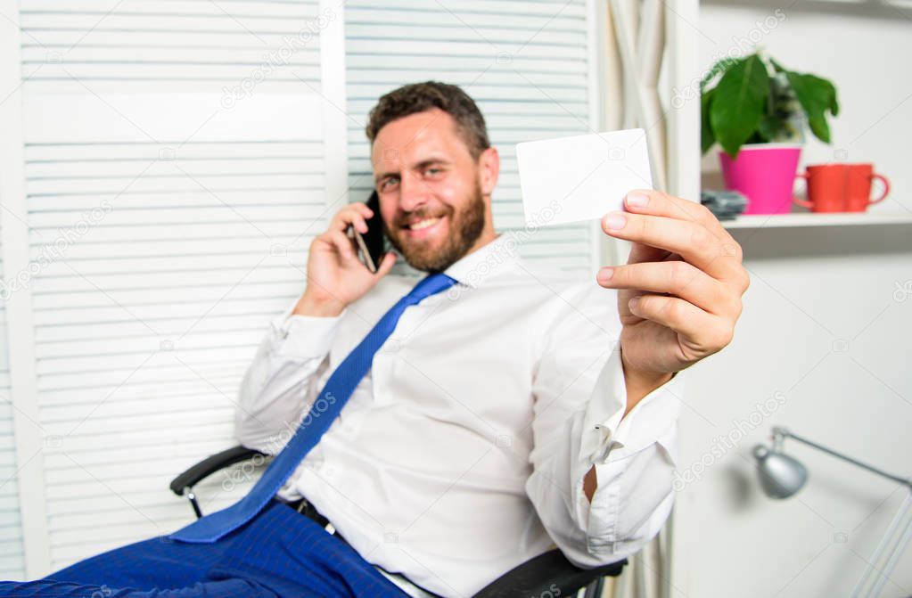Man successful businessman phone conversation ask service. Businessman bearded guy sit office feel confident. Man hold business or bank card copy space. Here is my number. Feel free to contact me